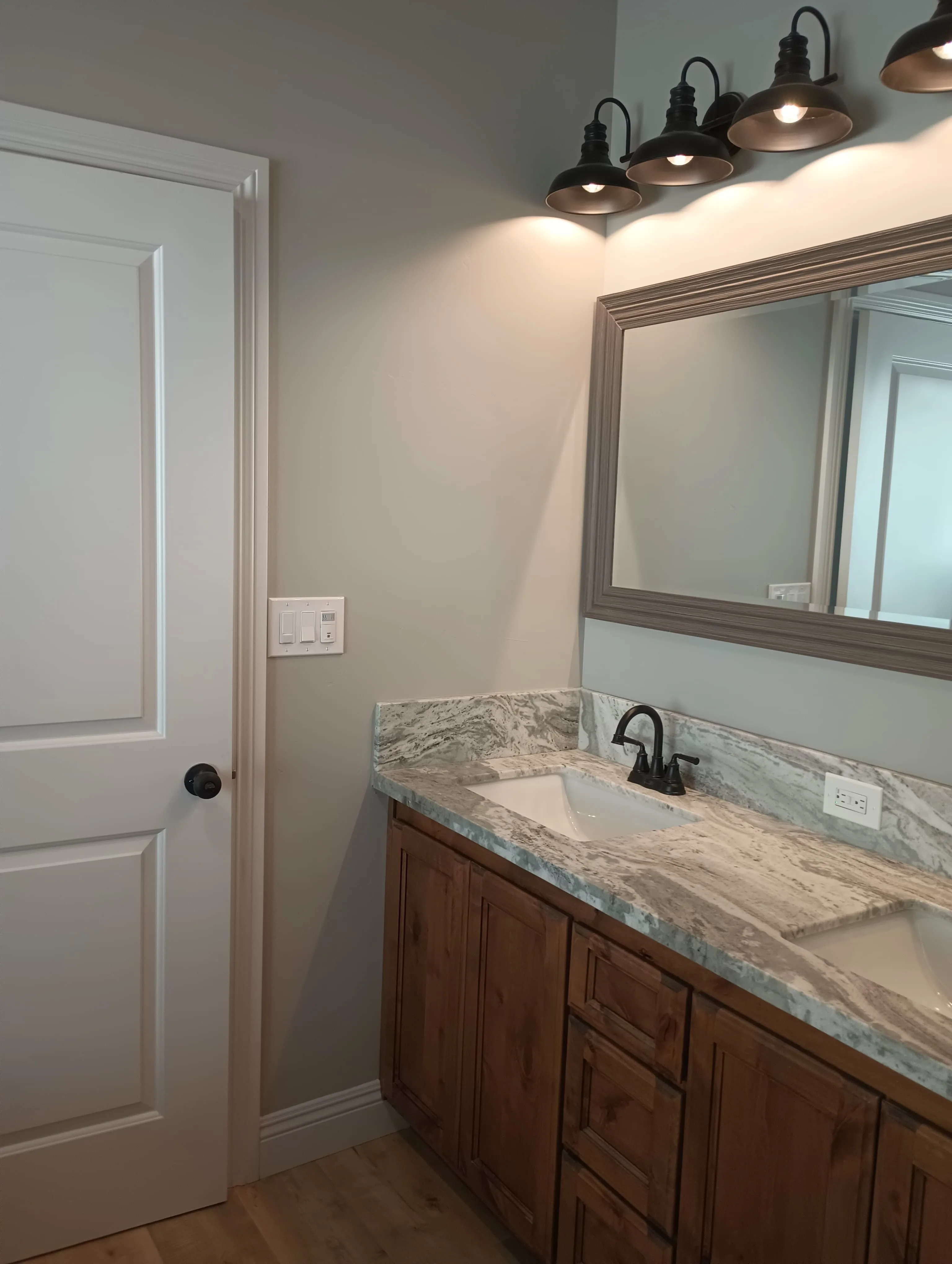 Completed rustic dual-sink bathroom vanity with marble top and matte black fixtures